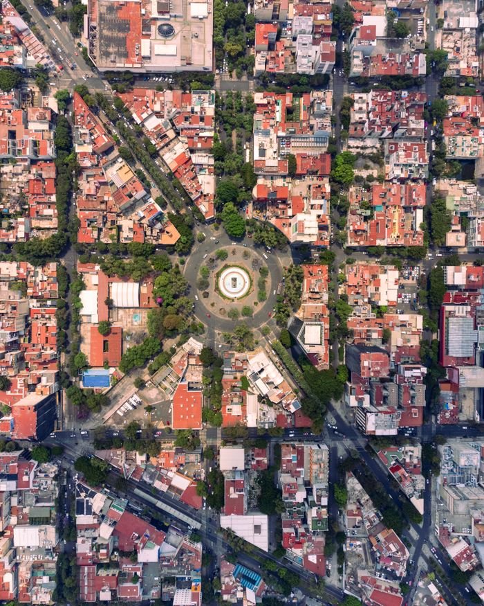 Stunning aerial view showcasing the vibrant urban grid and lush roundabout of Mexico City.
